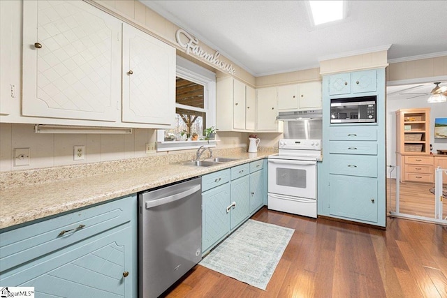 kitchen with stainless steel appliances, crown molding, sink, white cabinets, and dark hardwood / wood-style floors