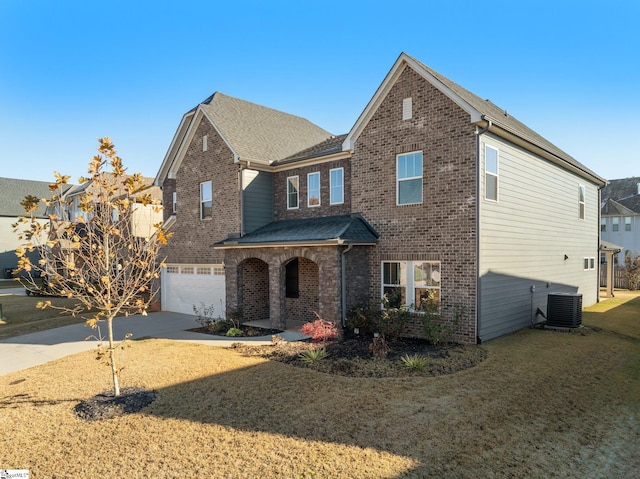 view of property with a garage, a front yard, and central AC