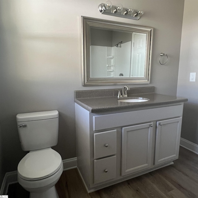 bathroom featuring vanity, hardwood / wood-style flooring, and toilet