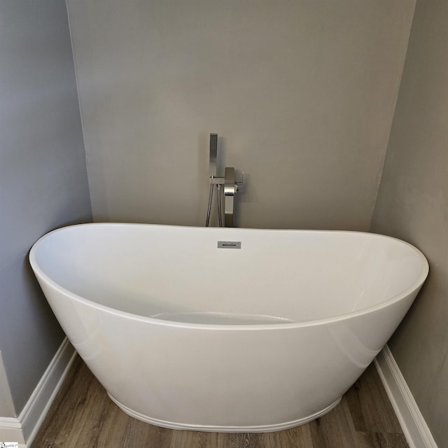 bathroom with hardwood / wood-style flooring and a bathing tub