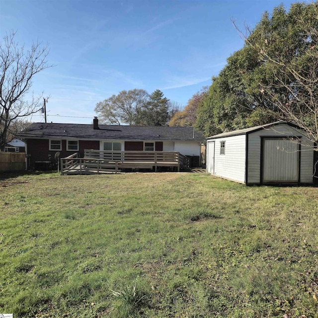 back of house with a lawn, a storage shed, and a wooden deck