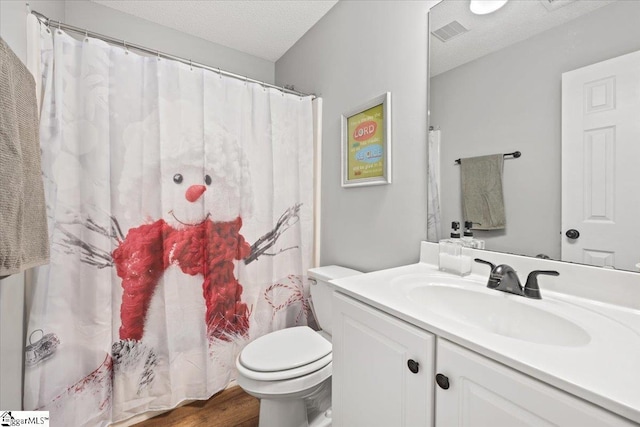 bathroom with hardwood / wood-style flooring, vanity, toilet, and a textured ceiling