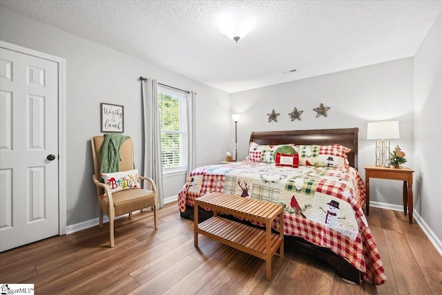 bedroom with a textured ceiling and hardwood / wood-style flooring