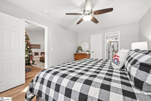 bedroom featuring ensuite bathroom, ceiling fan, a textured ceiling, and light wood-type flooring