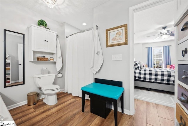 bathroom with ceiling fan, hardwood / wood-style floors, a textured ceiling, and toilet