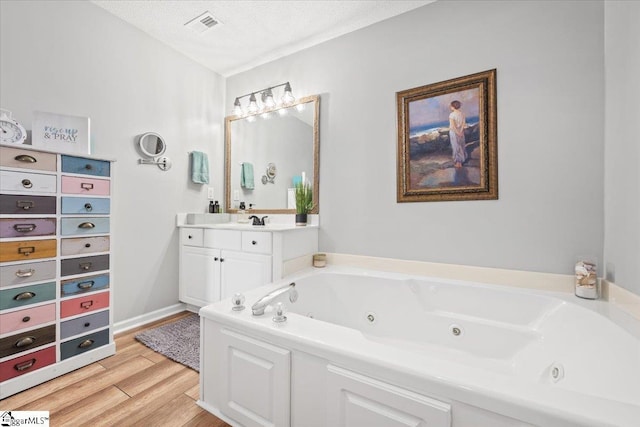 bathroom featuring a tub, vanity, a textured ceiling, and hardwood / wood-style flooring