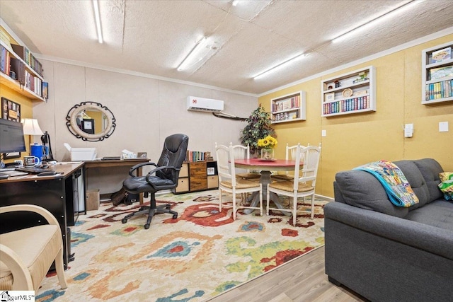 home office featuring an AC wall unit, light hardwood / wood-style floors, a textured ceiling, and ornamental molding