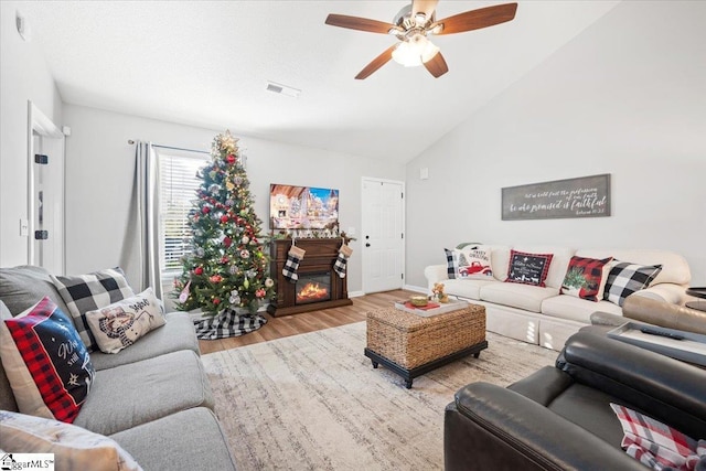 living room featuring lofted ceiling, ceiling fan, and wood-type flooring