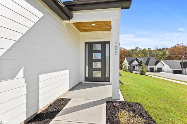 view of exterior entry with a lawn