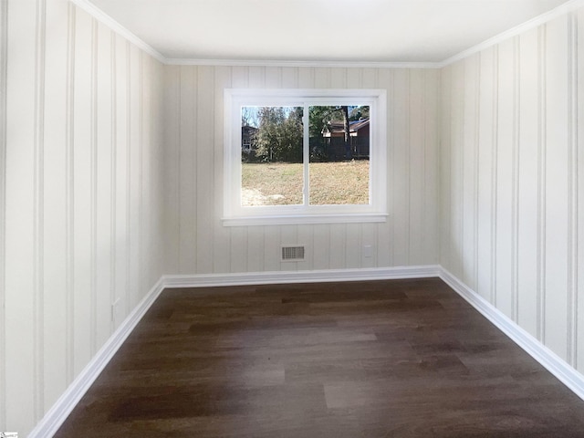 spare room featuring crown molding and dark wood-type flooring