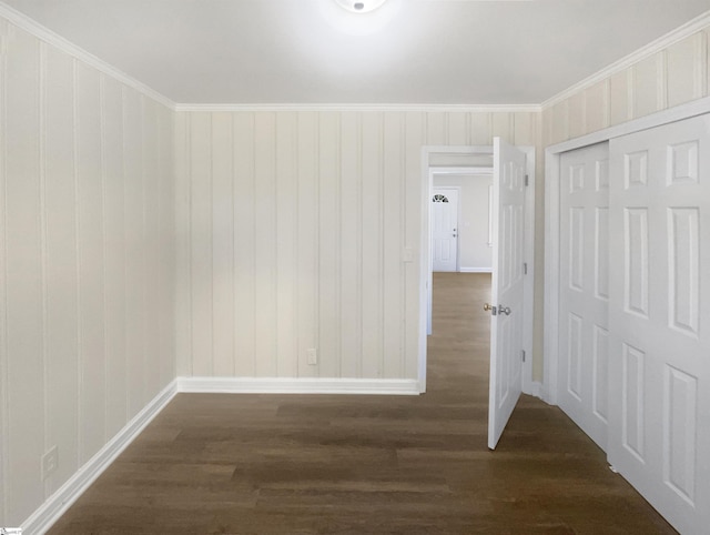 empty room featuring dark hardwood / wood-style flooring and ornamental molding