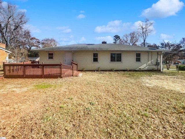 rear view of house with a lawn and a deck