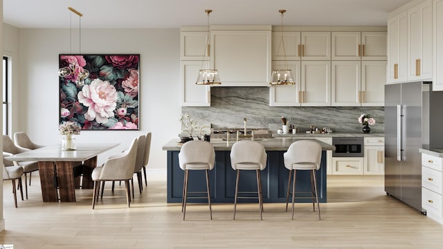 kitchen with decorative backsplash, stainless steel appliances, decorative light fixtures, light hardwood / wood-style flooring, and white cabinets