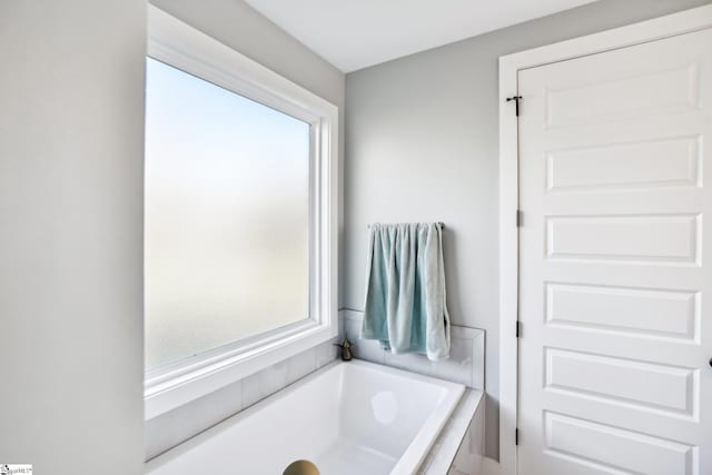 bathroom featuring a tub to relax in and plenty of natural light