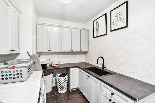 laundry room with sink, cabinets, dark tile patterned flooring, and independent washer and dryer