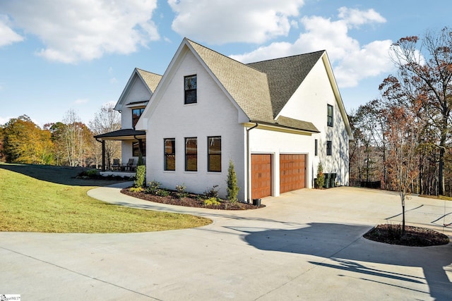 view of side of property with a garage and a lawn