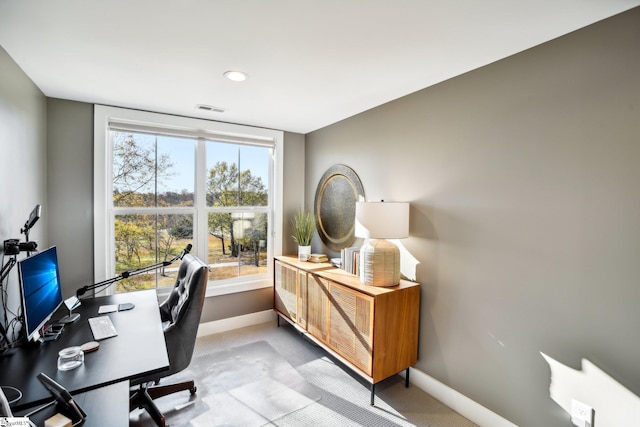 carpeted home office with plenty of natural light