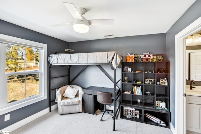 carpeted bedroom featuring ceiling fan and sink