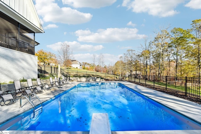 view of swimming pool featuring a diving board