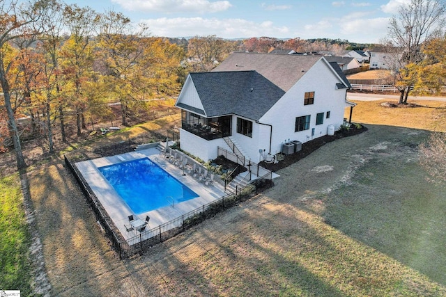 view of pool with central AC unit and a yard