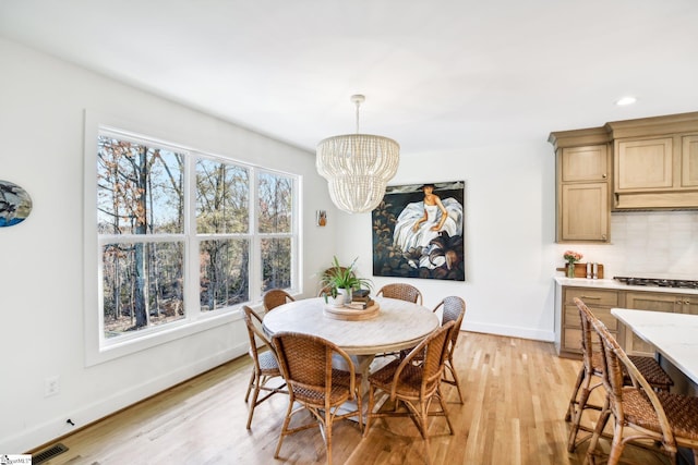 dining room with a chandelier and light hardwood / wood-style floors