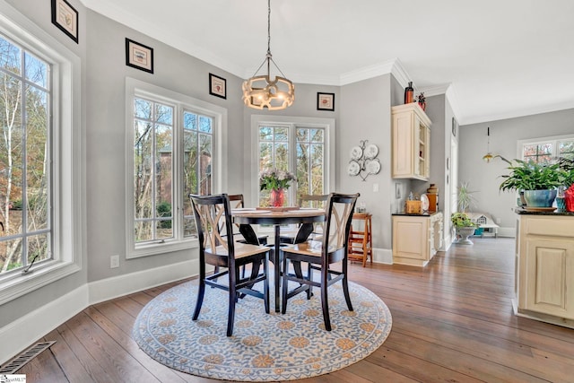 dining space with a chandelier, dark hardwood / wood-style flooring, crown molding, and a healthy amount of sunlight