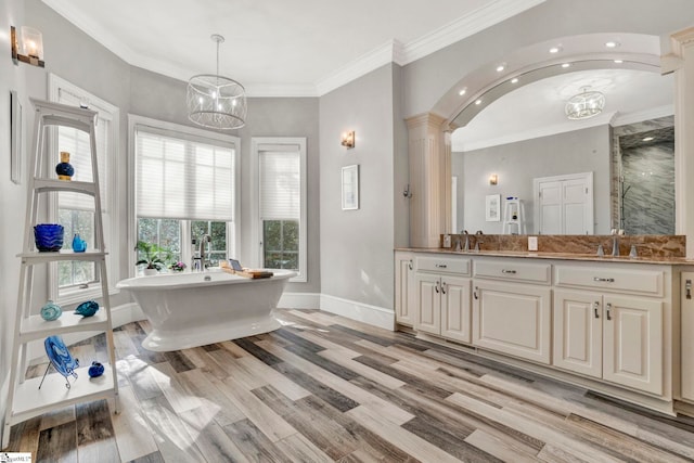 bathroom with hardwood / wood-style floors, vanity, an inviting chandelier, and ornamental molding