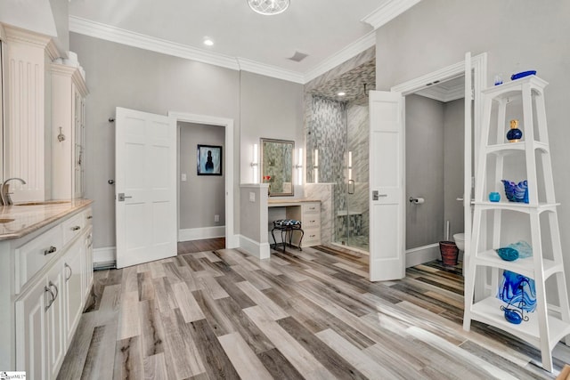 bathroom featuring vanity, wood-type flooring, and crown molding