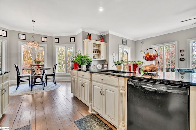 kitchen featuring cream cabinets, dishwasher, hanging light fixtures, and sink