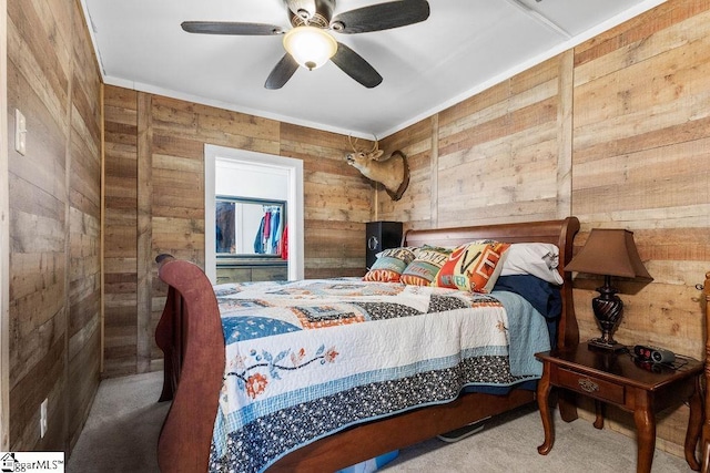 carpeted bedroom featuring ceiling fan and wood walls