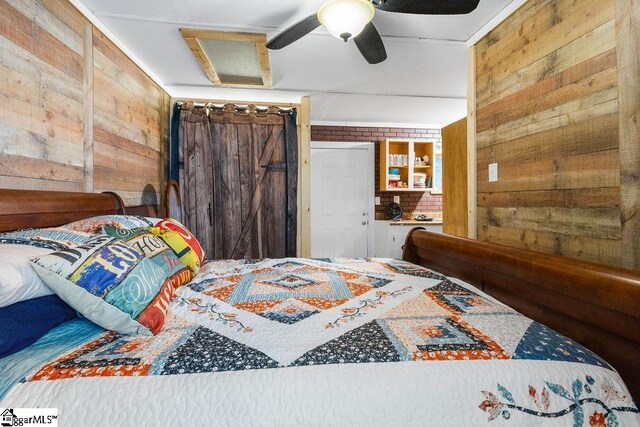 bedroom with ceiling fan and wooden walls