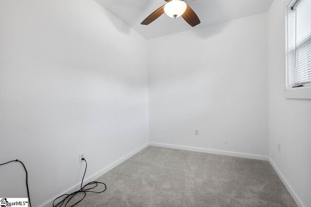 carpeted spare room with ceiling fan and lofted ceiling