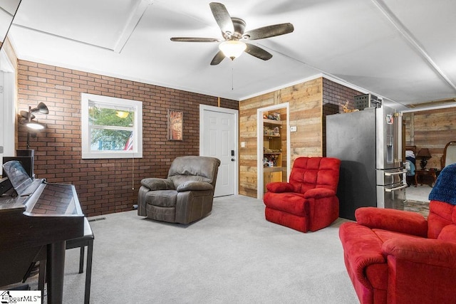 carpeted living room featuring wooden walls, ceiling fan, and brick wall