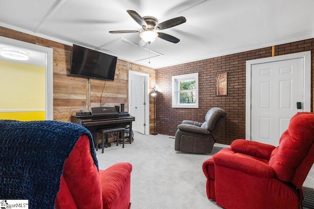 living room with ceiling fan, wooden walls, light colored carpet, and brick wall