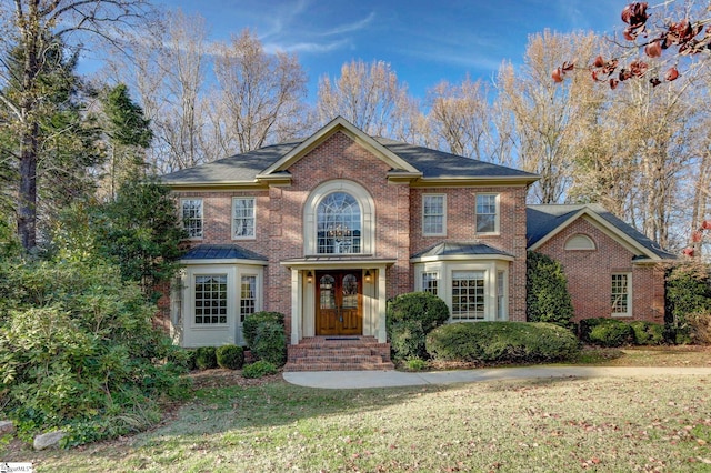 colonial house with french doors and a front yard