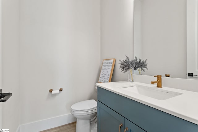 bathroom with hardwood / wood-style flooring, vanity, and toilet