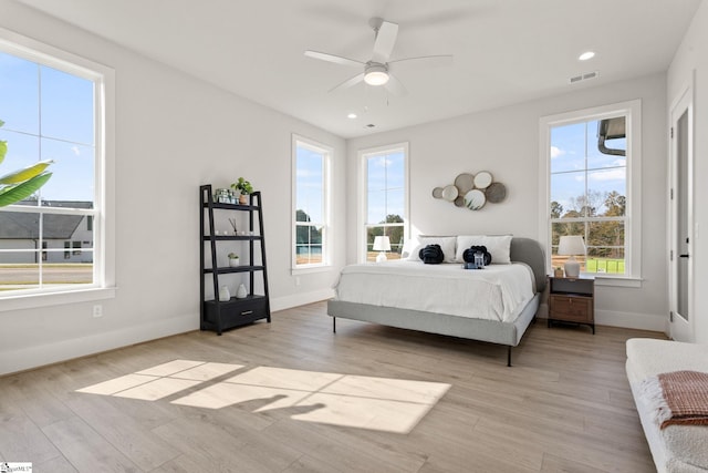 bedroom featuring multiple windows, ceiling fan, and light hardwood / wood-style floors