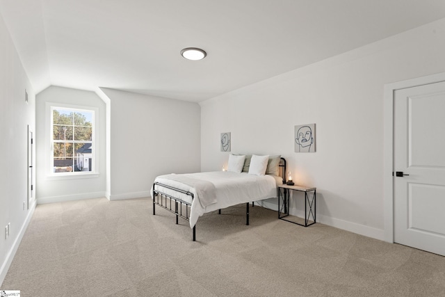 bedroom with light carpet and vaulted ceiling