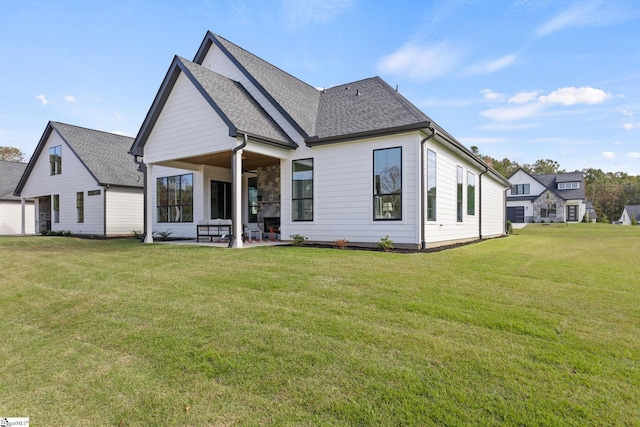 back of property with a lawn and a patio