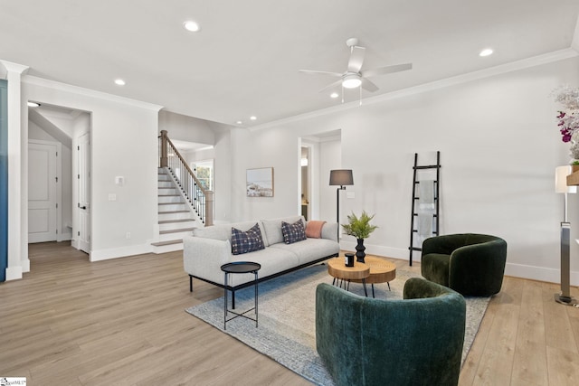 living room with ceiling fan, ornamental molding, and light hardwood / wood-style flooring