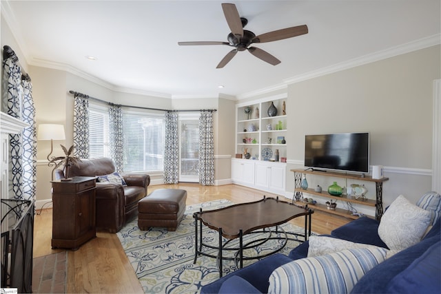 living room with ceiling fan, a fireplace, light wood-type flooring, and crown molding