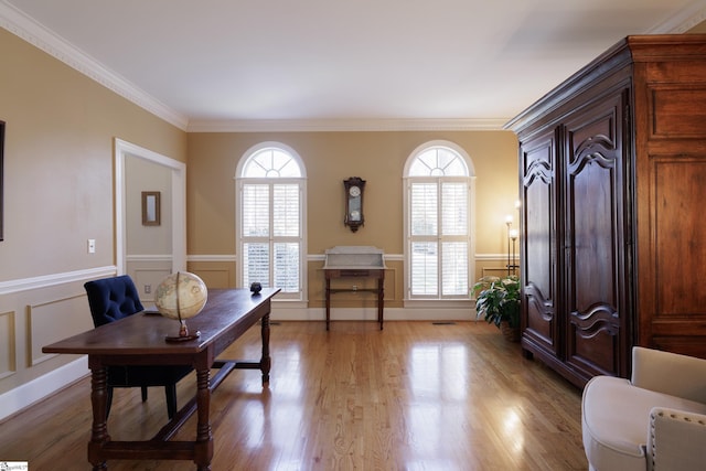 office with ornamental molding and light hardwood / wood-style flooring