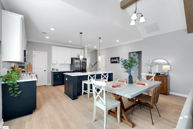 dining room featuring light hardwood / wood-style flooring, an inviting chandelier, and ornamental molding