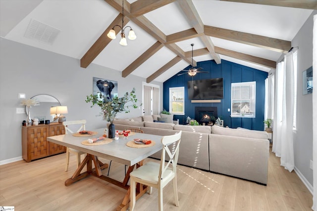 dining space featuring light hardwood / wood-style flooring, lofted ceiling with beams, and ceiling fan with notable chandelier