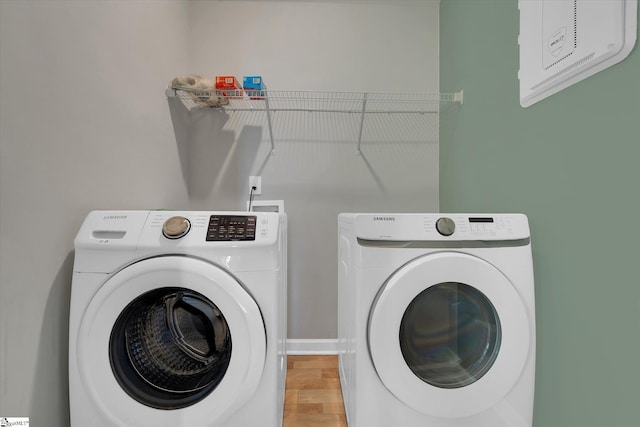 laundry room featuring light wood-type flooring and washing machine and dryer