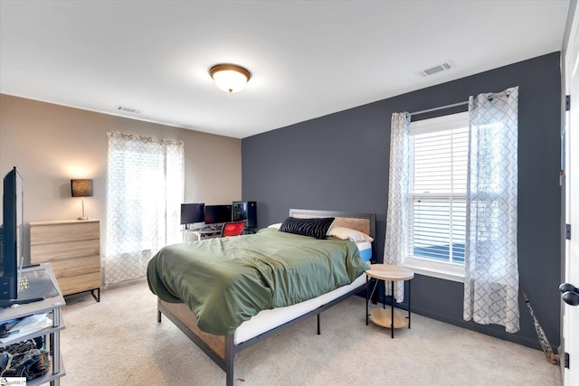 bedroom with light carpet and multiple windows