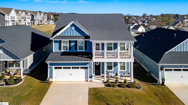 view of front of property featuring a balcony, a front lawn, and a garage