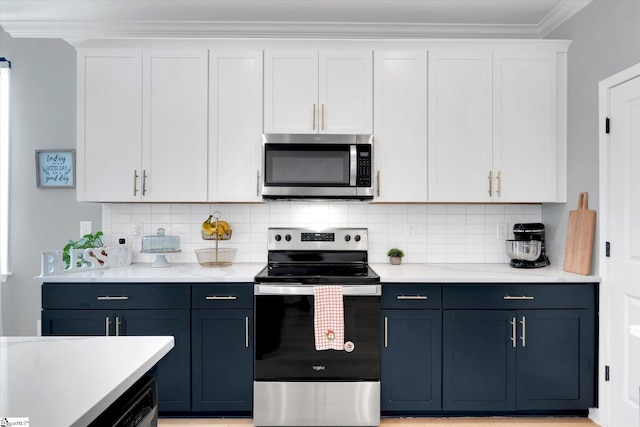 kitchen featuring backsplash, crown molding, white cabinets, and appliances with stainless steel finishes