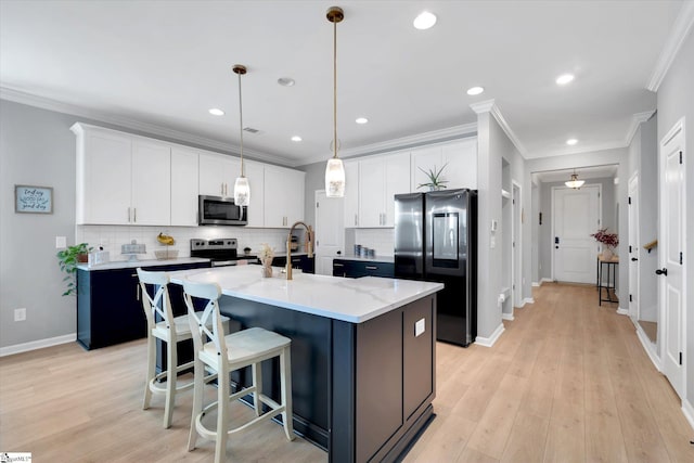 kitchen featuring stainless steel appliances, sink, a center island with sink, light hardwood / wood-style flooring, and white cabinets