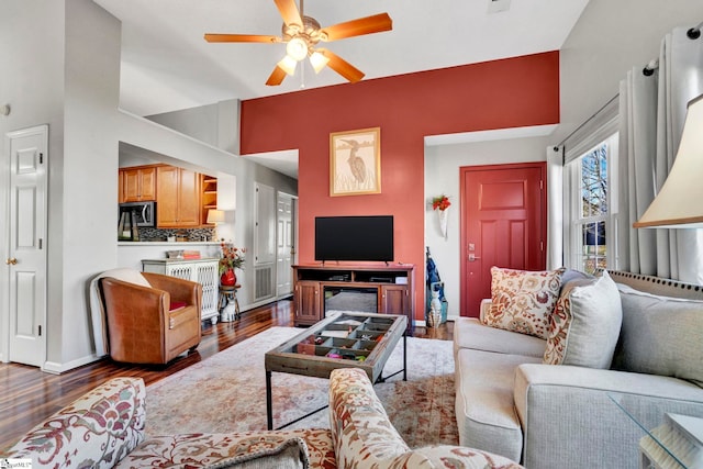 living room featuring ceiling fan and dark hardwood / wood-style flooring